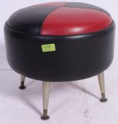 A retro two tone vinyl red and black footstool pouffe, standing on tapered retro legs.