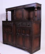A 1940's oak Jacobean court cupboard having cupboards to base with further cupboards atop on turned