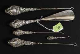 A set of hallmarked silver shoe horns and eyes, each with decorative hallmarked silver handles.