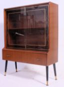 A compact vintage mid 20th century  drinks cocktail cabinet having detailed sliding glass doors
