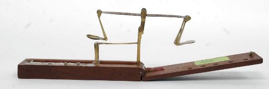 A small set folding coin scales set within a mahogany case.