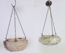 A non matching pair of suspended ceiling light shades, the first a white glass mottled with pink,