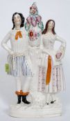 A Victorian large Staffordshire flatback figurine of a gentleman and lady either side of a vase of