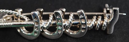 A white metal 925 silver good luck horse shoe brooch