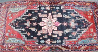 A good handwoven Persian Islamic rug having central black ground with tree of life medallions.