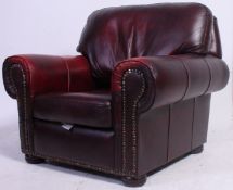 A Victorian Chesterfield style armchair in oxblood red leather finished with brass studded