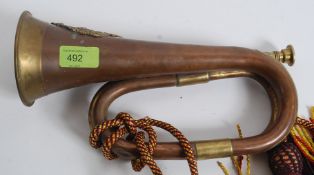 A believed 19th cenutry brass mounted copper military bugle horn being applied with the badge of