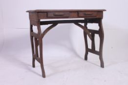 An early 20th century oak Arts & Crafts side / writing table raised on lyre shaped supports united