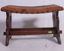 An early 20th century  leather button back stoo over oak base united by stretchersl.