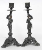 A pair of cast metal 19th century candlesticks having maiden and gentleman columns with single