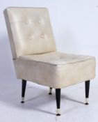 A vintage 1950's retro faux cream leather chair having button backed upholstery being raised on