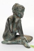 A bronze figurine of a seated nude femal