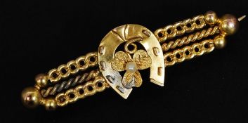 A 9ct gold bar brooch with central horseshoe and clover motif set with  a seed pearl.