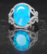 A ladies 925 silver cz and opal dress ring of ribbon form with central cabochon cut opal.