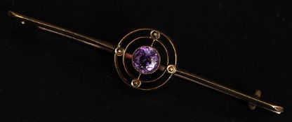 A 9ct gold bar brooch with central amethyst stone set within twin circles. Marked 9ct. Weight 4g.