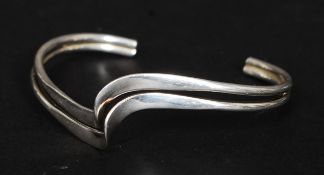 A 20th century contemporary twin swirl wishbone bangle - bracelet. Stamped 925.