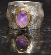 A designer silver 925 band ring with central amethyst stone with yellow metal mount. Size R.5. 8.