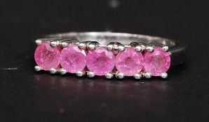 A silver 925 ladies dress ring having 5 channel set pink sapphire style gemstones. Size N.5.
2.