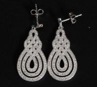 A pair of large decorative silver and cz earrings of scrolled form. Total weight 6.