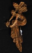 A Yellow metal Art Nouveau brooch in the form of a  stylised fairy holding a posy of flowers.