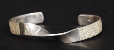 A 20th century decorative ladies silver 925 bangle with planished finish having twist centre.