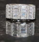 A contemporary  silver cz dress ring, the stones being baguette cut and inset to centre.