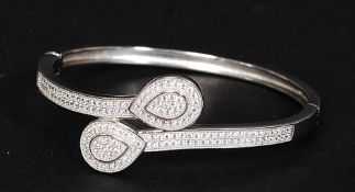 A ladies 925 silver and cz stone inset crossover bangle with teardrop shaped heads. Total weight 16.