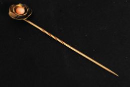A 15ct gold flower head stick pin with inset pink agate / coral  type stone to centre.