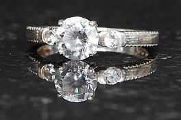 A ladies silver 925 dress ring with round cut CZ stone being claw mounted having round cut shoulder