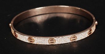 A silver gilt cartier style bangle with CZ stones all around the central roundels. Total weight 17.