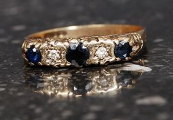 A hallmarked 9ct gold ring set with 2 2pt diamonds a central garnet and two sapphires. Weight 2.2g.