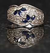 An Art Deco style ladies silver 925 dress ring set with petal cut sapphires and round cut cz stones.