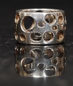 A silver modernist ladies dress ring of pierced band form with graduating circle style. Size L.