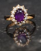 An antique 9ct gold cluster ring set with central purple stone surrounded by seed pearls marked 9ct.