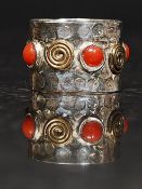 A designer 925 silver dress ring set with coral type stones and yellow metal over a planished