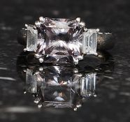 A silver ladies 925 stamped amethyst ring. Claw mounted stones with pierced shoulders. Size L.