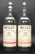 A pair of vintage oversized shop advertising Bells Whiskey bottles.