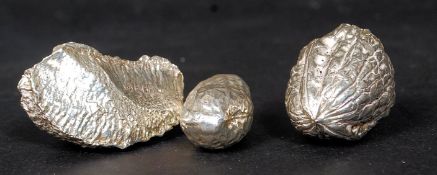 A collection of 3 silver nuts to include brazil nut, walnut and monkey nut.