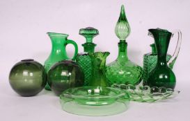 A collection of green glass of various designs to include vases, decanters, orbs,