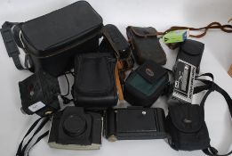 A collection of cased vintage cameras to include Kodak and many more examples