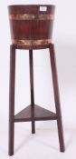 An early 20th century coopered oak barrel plant stand - jardiniere on tripod base with under tier.