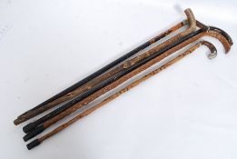 A collection of walking sticks to include white metal collars, horn handled, crook neck.