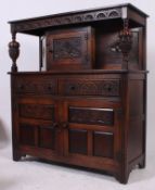 A Jaycee oak court cupboard having carved panel doors with shaped upright gallery back having