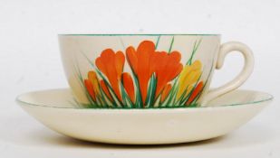 A Clarice Cliff globe shape teacup and saucer circa 1930's being hand painted with banded borders