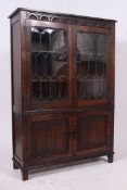 A Jaycee oak china - bookcase display cabinet having leaded glass doors with further cupboard
