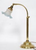 A good brass bankers lamp raised on angular stem with terraced base having frosted blue glass shade