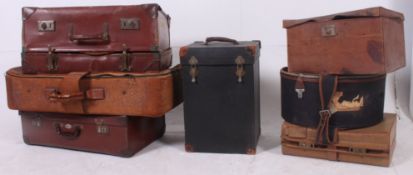 A stack of vintage suitcases to include leather, vinyl,