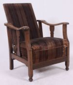 A 1940's vintage oak reclining fireside chair raised on squared legs with original upholstery.