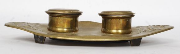 A 19th century Geschutzt brass inkwell in the high Art Nouveau form having twin wells with ceramic
