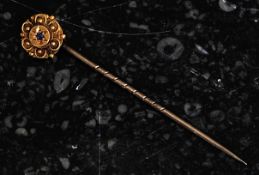 A 15ct gold vintage stick pin with inset  sapphire to the flower head top. 1.